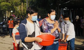 Người Sài Gòn đeo khẩu trang, thả cá chép đưa ông Táo về trời