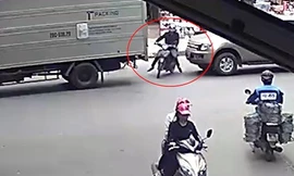 Xe máy cố sang đường bị ô tô đâm trúng, ép kẹt vào đuôi xe tải