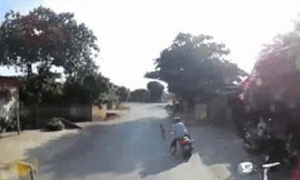 Tránh trẻ chạy sang đường, 2 người đi xe máy ngã dúi dụi trước container