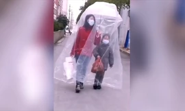 Hai mẹ con đeo khẩu trang và trùm túi nhựa kín mít chống virus corona