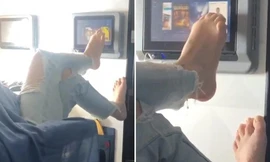 Người phụ nữ dùng chân vuốt màn hình tivi trên máy bay