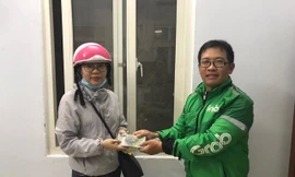 Anh Huy (bên phải) trao lại số tiền 100 triệu đồng cho người đánh rơi. Ảnh người dân cung cấp.