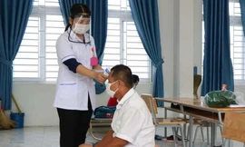 Nhân viên y tế Ninh Thuận đo thân nhiệt cho người dân trong khu cách ly. Ảnh L.H