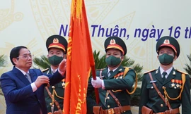 Thủ tướng Phạm Minh Chính gắn Huân chương Lao động hạng Nhất lên cờ truyền thống của tỉnh Ninh Thuận. Ảnh CÔNG HOAN.
