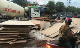 Giao thông hỗn loạn khi hàng trăm tấn ván ép trên container bung dây 