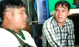 Hiếu (bìa phải) nhờ hiệp sĩ Hải đưa đến công an đầu thú