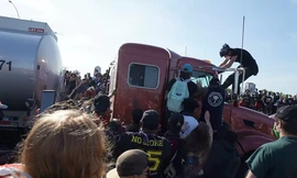 Sau khi chiếc xe dừng lại, đoàn người biểu tình ùa tới để kéo tài xế trên xe ra ngoài. Ảnh: AP.