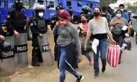 Cảnh sát Guatemala ngăn chặn người di cư trong hành trình tới Mỹ tại khu vực Cofradia, Honduras, ngày 15/1/2021. Ảnh: THX/TTXVN