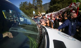 Người biểu tình bao vây chiếc xe chở Tổng thống Alberto Fernandez. Ảnh: Reuters