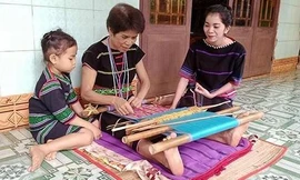 Nghệ nhân Thị An Đê (xã Thọ Sơn, huyện Bù Đăng, Bình Phước) truyền nghề dệt thổ cẩm truyền thống cho con cháu. (Ảnh: Nhất Sơn)