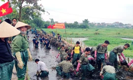 Bộ đội Đặc công tham gia giúp dân làm sạch kênh mương, cải tạo môi trường trên địa bàn huyện Thanh Trì, Hà Nội. Ảnh: Hồng Lương