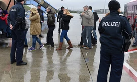 Những người xin tị nạn được hộ tống lên máy bay tại miền nam nước Đức. Ảnh: AP