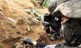 Các binh sĩ khai quật hài cốt được cho là của một binh sĩ Hàn Quốc thiệt mạng trong Chiến tranh Triều Tiên 1950-1953 tại Khu phi quân sự ở Cheorwon, tỉnh Gangwo. Ảnh: Yonhap