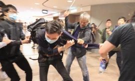 Cảnh sát mặc thường phục tấn công người biểu tình bằng gậy. Ảnh: SCMP.