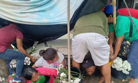 Những người bán hoa tại khu chợ ở Padada bị mắc kẹt dưới một bức tường sụp đổ do trận động đất mạnh 6,8 độ xảy ra vào chiều ngày 15/12. Ảnh: Twitter