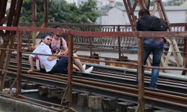 Du khách ngồi trên đường ray cầu Long Biên chụp ảnh