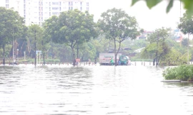 Đường và hồ 'hòa làm một', người dân run run bì bõm lội qua