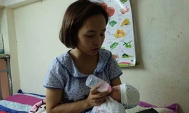 Chị Hòa đang chăm sóc cháu bé.