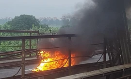 Chiếc xe máy bốc cháy ngùn ngụt giữa cầu Long Biên. Ảnh: CTV.