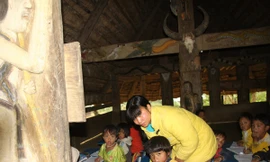 Cô giáo A Vô Thị Ngôn và lớp học trong nhà Gươl ở thôn Chà Nốc