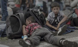 Ahmad, 7 tuổi, ngủ trên vỉa hè ở biên giới Hungary- Áo. Tại quê nhà ở Idlib, một quả bom rơi trúng nhà cậu khiến em trai cậu thiệt mạng.
