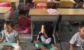 Thay vì ngủ trên giường sắt ở kí túc xá, các em học sinh tiểu học ở Quảng Đông, Trung Quốc sẽ ngồi thiền ngay trong lớp