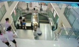 Người mẹ đang dắt con nhỏ đi trên thang cuốn thì tấm kim loại phía trên cùng bị sập xuống.