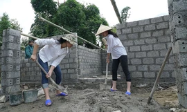 Các thí sinh trộn xi măng để xây trường học.