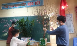 Anh Nguyễn Duy Long cùng hai con trai trang trí phòng cách ly để đón Tết. Ảnh: Nhân vật cung cấp.