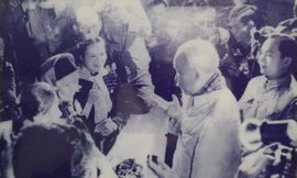 Trong ảnh, bà Diên quàng cổ chiếc khăn màu trắng