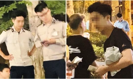 Nam thanh niên mặc áo phông đen sau khi thu tiền bán hàng rong đã mặc lại trang phục của Đội An ninh trật tự