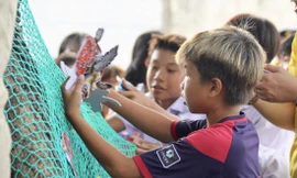 Các em nhỏ tham gia trò chơi giải cứu rùa biển để hiểu rõ về tác hại của những tấm lưới “ma”. Ảnh: NHẤT NGUYÊN