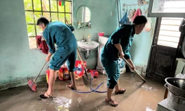 Lực lượng dân quân giúp người dân dọn bùn đất tràn vào nhà. Ảnh: T.T