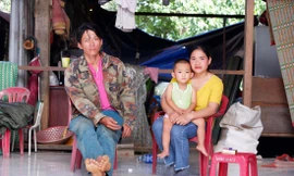 Anh Dương Văn Được cùng vợ con bên trong căn nhà đang làm dang dở. Ảnh: Nguyễn Thành 