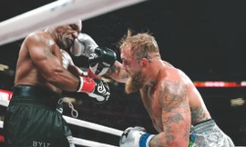 Mike Tyson (trái) chịu đựng cú đấm của đối thủ. Ảnh: Getty Images 