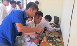 Anh Trần Minh Khánh (áo xanh), Bí thư Ðoàn phường Quyết Tâm (TP Sơn La) và cộng sự sửa chữa máy vi tính cũ để tặng học sinh có hoàn cảnh khó khăn