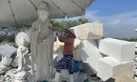 Bà Huỳnh Thị Mười đang hoàn thiện bức tượng Phật. Ảnh: Minh Hiền