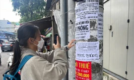 Sinh viên tìm thông tin phòng trọ trên tờ rơi dán trước cổng Trường ĐH Giao thông vận tải TPHCM. Ảnh: Nhàn Lê