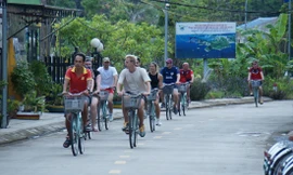 Khách du lịch quốc tế trải nghiệm đạp xe trên làng chài Việt Hải, Cát Bà. Ảnh: Nguyễn Hoàn