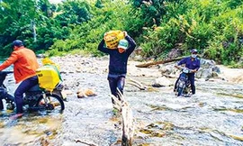 Đoàn viên thanh niên Huyện Đoàn Nam Giang băng rừng, lội suối vận chuyển vật liệu xây “Mái ấm biên cương”. Ảnh: Nguyễn Thành