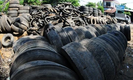 Lốp xe phế thải chất cao như núi, tràn từ vườn nhà dân ra đường cái ở thôn Hòa Bình, xã Nghĩa Hòa, huyện Tư Nghĩa. 