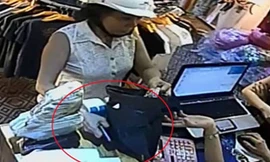 Cầm lấy túi đựng quần áo nhân viên đưa cho, nữ hành khách cố tình che chiếc iPhone 5 của nhân viên để giữa bàn.