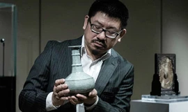 Trong ảnh là nhân viên giao dịch của Chi nhánh Nhà bán đấu giá Sotheby’s ở Hồng Kông (Trung Quốc), đang giới thiệu với khách hàng một chiếc lọ cổ bằng gốm có niên đại gần 9 thế kỷ