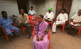 Những người lớn tuổi đang tìm cách bảo vệ một phụ nữ bị cáo buộc sử dụng tà thuật ở làng Dabang, bang Bihar, Ấn Độ, tháng 7/2000. Ảnh: AP.