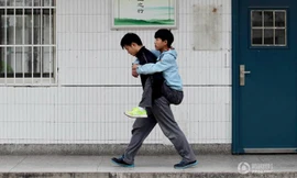 Tạ Húc cõng Trương Trì lên lớp mỗi sáng. Ảnh: QQ.