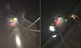 Cô bạn gái cũ (áo đỏ) bị ngập trong bùn sau khi nhảy xuống sông. Đội cứu hộ phải dùng dây thừng buộc quanh người để kéo cô gái lên.