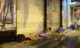 Người vô gia cư mặc áo mưa ngủ vỉa hè trong đêm giá