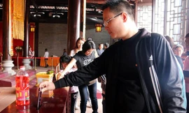 Một người đàn ông bỏ cả chiếc iPhone 6 vào hòm công đức.