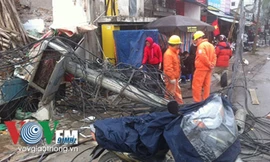 Chiếc cột điện bật gốc, ngã nhào xuống đường.