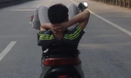 Nam thanh niên nằm ngửa, lái xe ga bằng chân
